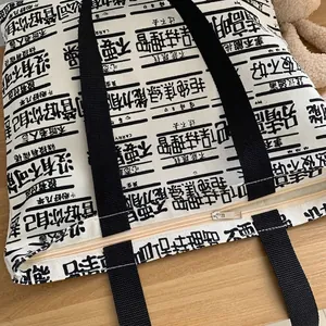 Minimalist canvas tote bag with black letter print and secure zipper closure for students