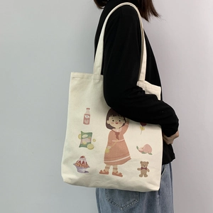 Detail of canvas tote bag featuring cute cartoon girl illustrations and sturdy handles