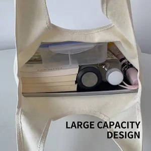 Minimalist white canvas tote bag with large capacity showing books and laptop inside