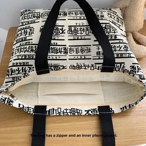 Internal detail of large canvas tote bag showing zipper closure and phone pocket compartment