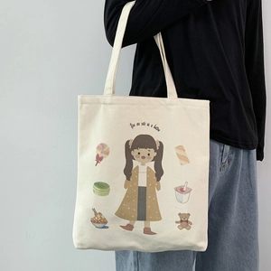 Detail of cute canvas tote bag featuring a cartoon girl print and soft cotton texture
