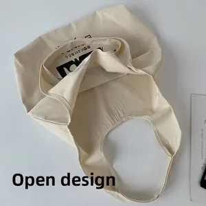 Détail de l'intérieur du sac cabas en toile beige avec un design ouvert sans fermeture éclair