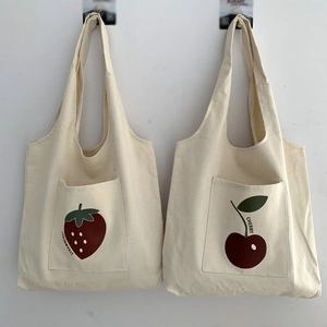 Close-up of minimalist canvas tote with cherry and strawberry illustration pockets