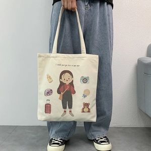 Close-up of canvas tote bag with artistic European illustration and slogan on fabric