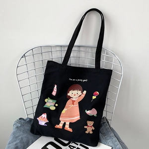 Detail of a black canvas tote bag featuring a colorful cartoon girl and snacks print