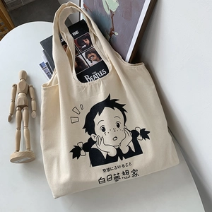 Sac cabas en toile beige avec imprimé fille cartoon et texte sur bureau blanc