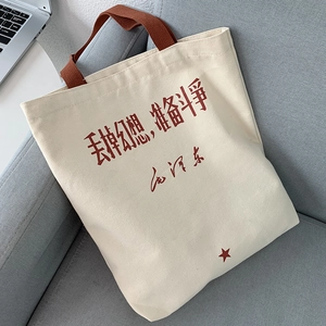 Detail view of canvas tote bag with red star and Chinese calligraphy on gray sofa