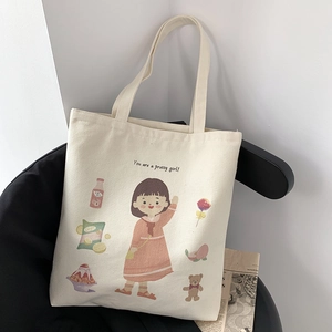 Detail of white canvas tote bag featuring a cute girl illustration and soft long handles