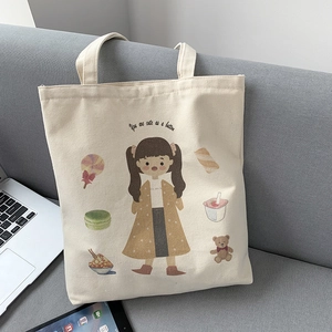 Close-up of cute girl illustration on white canvas tote bag against a sofa backdrop