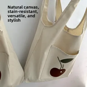 Detail of original canvas tote bag with cherry print and front pocket structure