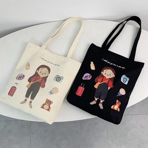 Close-up of canvas tote bags with artistic girl illustration and colorful graphics