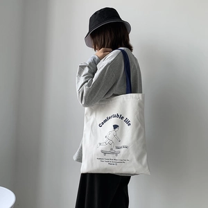 Thick canvas tote bag detail showing navy blue shoulder strap and skateboarder print