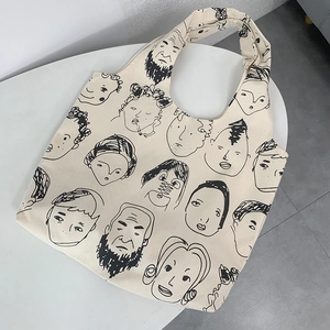 Detail of artistic minimalist line art portraits on a large cream canvas tote bag