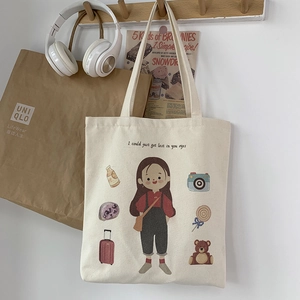 Detail of artistic illustration on off-white canvas tote bag featuring girl and lifestyle icons