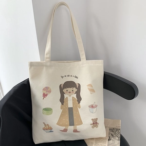 Detailed view of cream canvas tote bag featuring cute cartoon girl and playful hand-drawn art