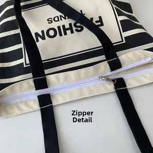 Detail view of the durable white zipper closure on a striped canvas tote bag
