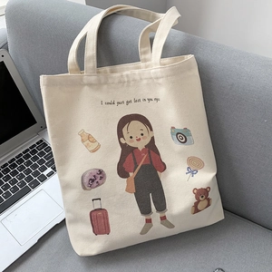Detail of cream canvas tote bag with artistic girl illustration on a sofa