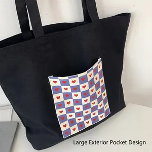 Black canvas tote bag featuring large blue checkerboard pocket with red heart patterns