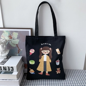 Detail of black canvas tote bag with cute cartoon girl print and button text
