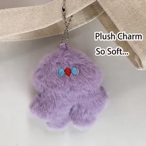 Minimalist canvas shoulder bag with a fluffy purple plush charm and cute embroidery details