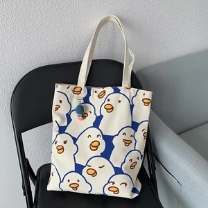 Minimalist white canvas tote bag with blue duck patterns and yellow beak details