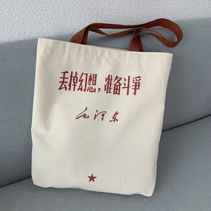 Detail of canvas tote bag with red calligraphy slogan and sturdy brown handles