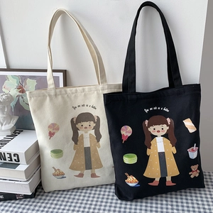 Detailed view of canvas tote bags with cute cartoon girl prints and cursive text