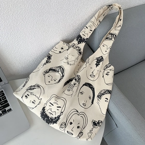 Detail of artistic canvas tote bag featuring dense black abstract face line illustrations