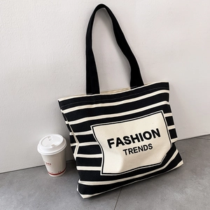 Minimalist black and white striped canvas tote bag with Fashion Trends printed on the front