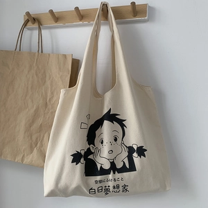 Détail du sac cabas en toile blanc cassé avec motif fille artistique et texte japonais