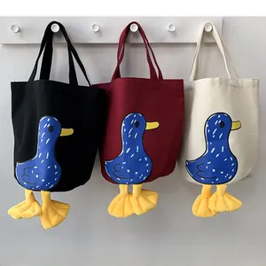 Detailed shot of canvas lunch bags in three colors with 3D plush duck feet decor