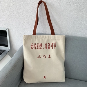Detail of canvas tote bag with red Chinese calligraphy text and brown cotton shoulder straps