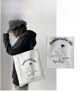 Detail view of white canvas tote bag with skateboarder print and durable handles
