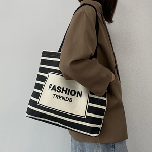 Detail of black and white striped canvas tote bag with Fashion Trends patch