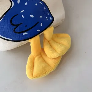 Close-up of canvas lunch bag featuring cute 3D yellow plush feet and cartoon print
