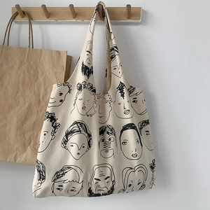 Close-up of thick canvas tote bag with artistic line art portrait graffiti patterns