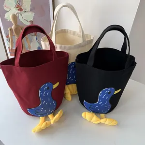 Detailed view of canvas lunch bags with duck patterns and cute 3D duck feet decorations