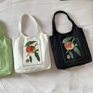 Détail à plat de sacs fourre-tout en toile avec imprimés de pêches vintage noir et blanc