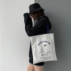 Detail of white canvas tote bag with black cartoon skater print and text design