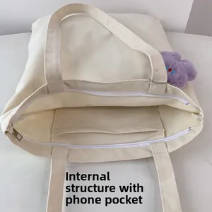 Detailed internal structure of beige canvas tote bag with zippered pocket and phone slot