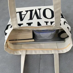 Internal view of beige canvas tote bag showing large capacity for books and tablet