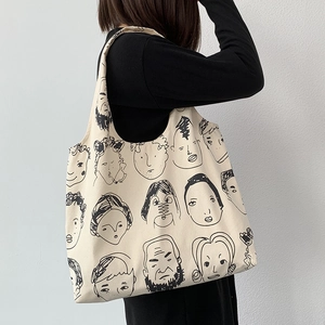 Artistic canvas tote bag with minimalist line art illustration shown on model shoulder