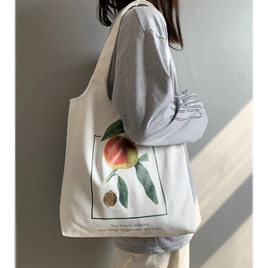 Détail du sac cabas en toile blanche avec illustration de pêche et texte imprimé