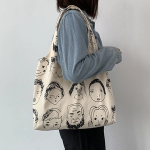 Close-up of cream canvas tote bag with minimalist line art portrait illustration