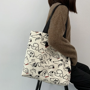 Detailed view of the ivory canvas tote bag with black dog prints and sturdy straps