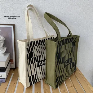 Close-up of olive and beige canvas tote bags with reinforced wide sides and ABLE logo