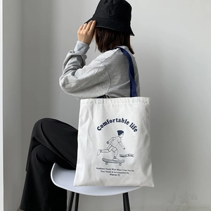 White canvas tote bag with blue handles and skateboard illustration for casual style