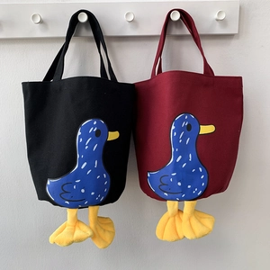 Detail of canvas bento bags featuring 3D duck feet and cute blue polka dot duck prints