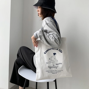 Detail of canvas tote bag showing the Comfortable Life skateboard graphic and texture