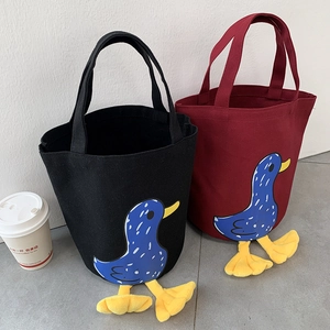 Detail of canvas bento lunch bags featuring cute 3D plush duck feet in black and wine red